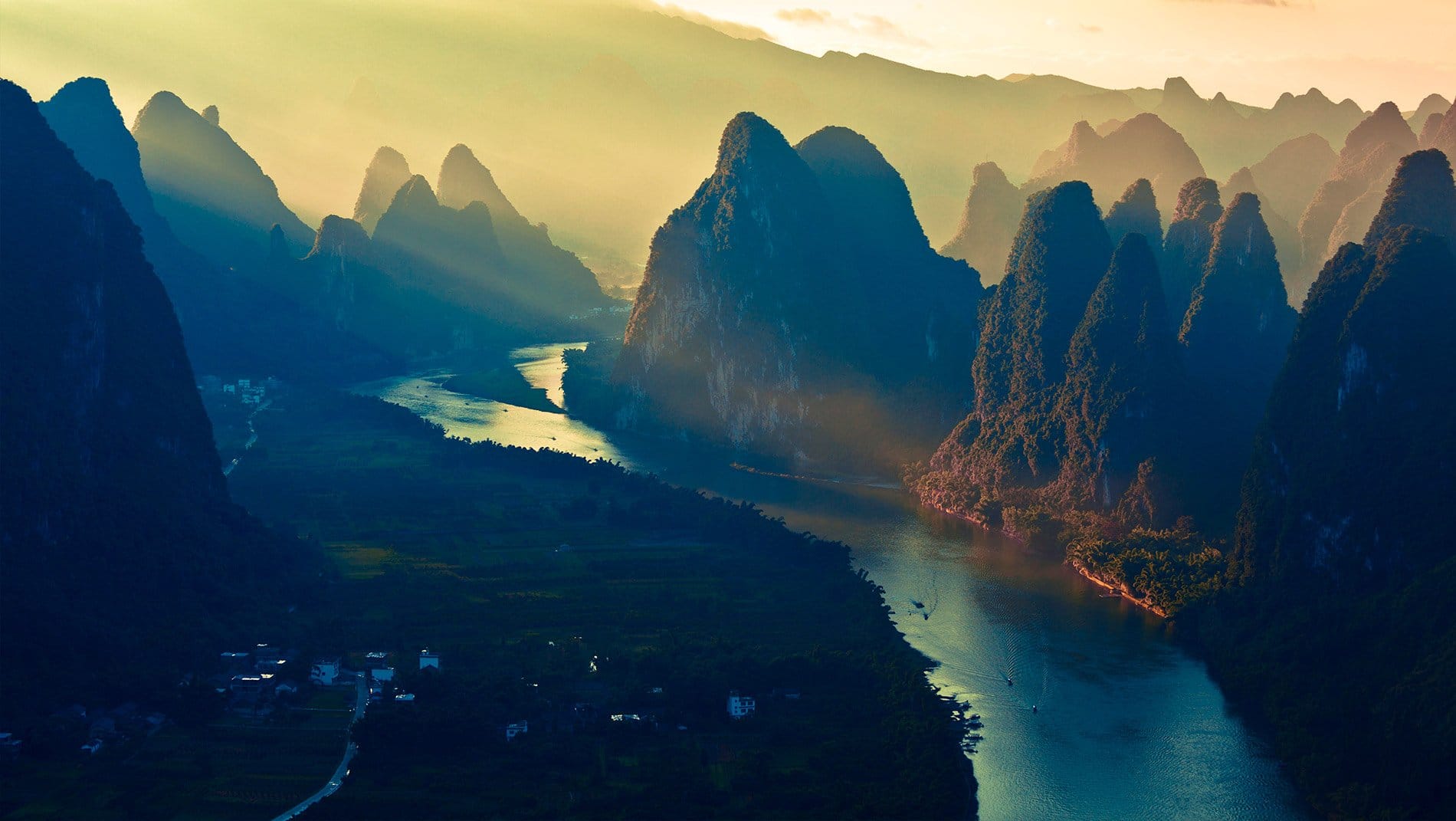 Karst Mountains~The erosion of a massive limestone block over tens of millions of years has left a phantasmagorical landscape of vegetation-encrusted towers and cones sowed together by a meandering river irrigating bountiful fields of fruit, rice and vegetables.